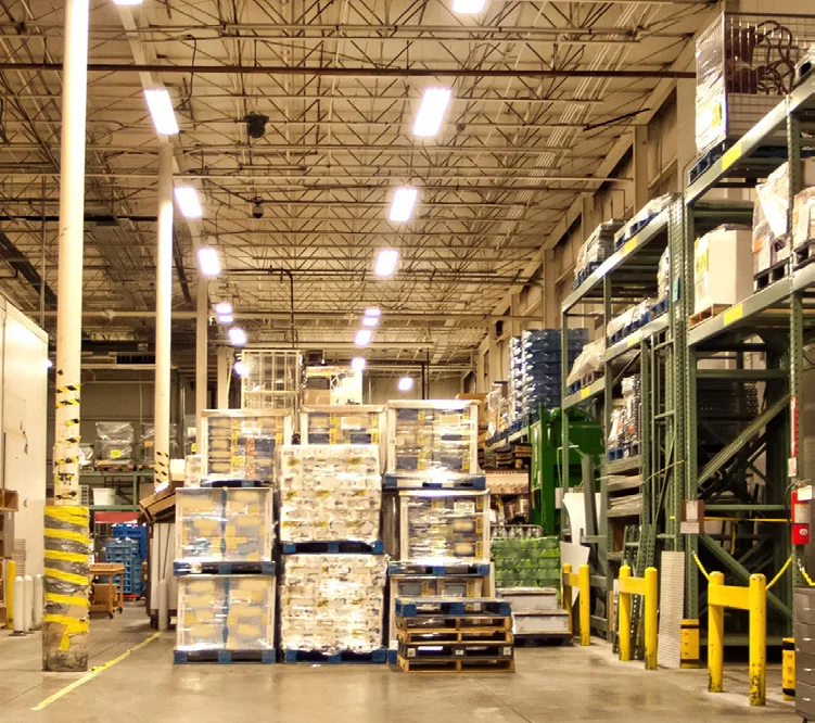 Pasillo de un centro de distribución con tarimas y racks de almacenamiento